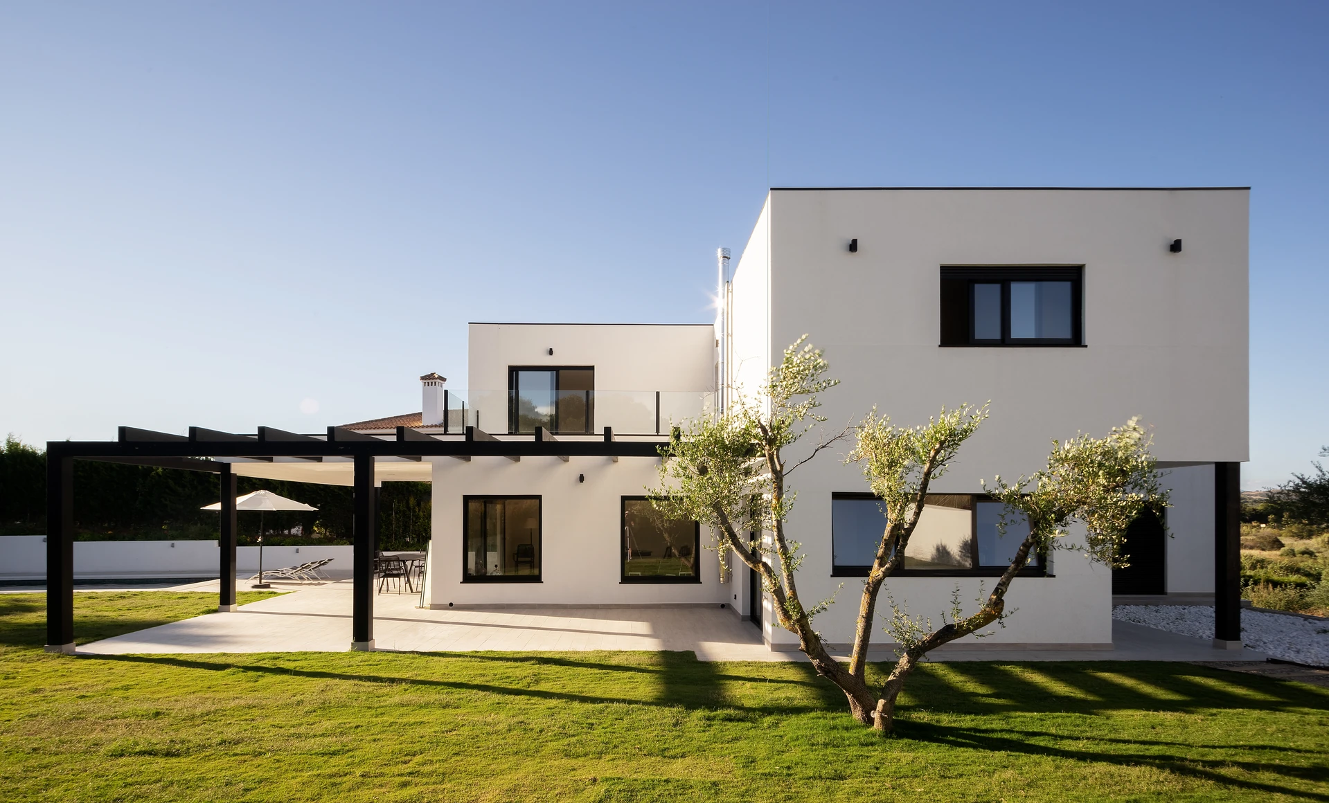 Façade provençale en enduit blanc, avec une porte d'entrée à deux vantaux en bois peint gris-bleu ardoise, style "porte de bergerie"
