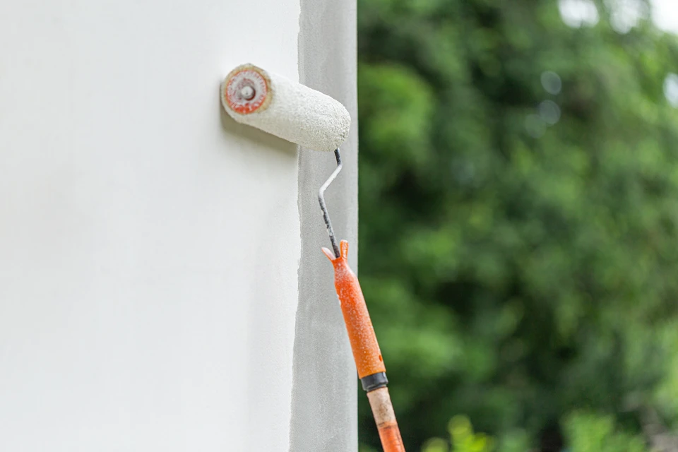 Façade de bâtiment en pierre calcaire beige avec fenêtre double vantail en PVC blanc